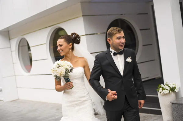 Los recién casados están caminando sobre el fondo del edificio . — Foto de Stock