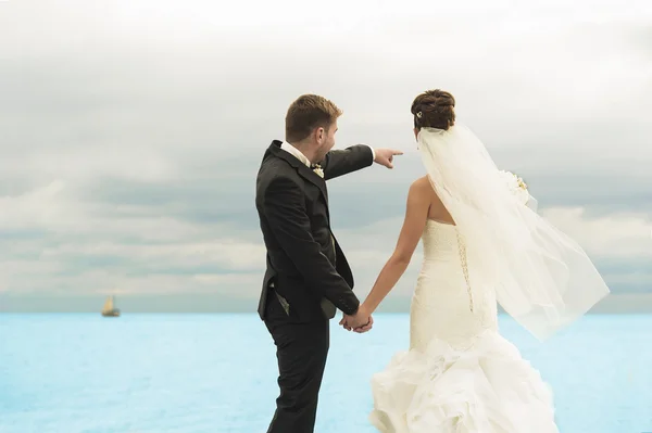 Belos recém-casados estão à beira do oceano. . — Fotografia de Stock