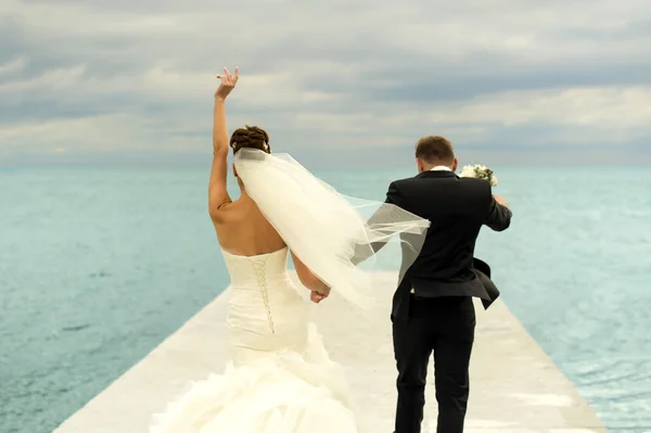 Belos recém-casados estão andando no cais . — Fotografia de Stock