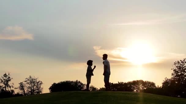 Enfants jouant au coucher du soleil . — Video