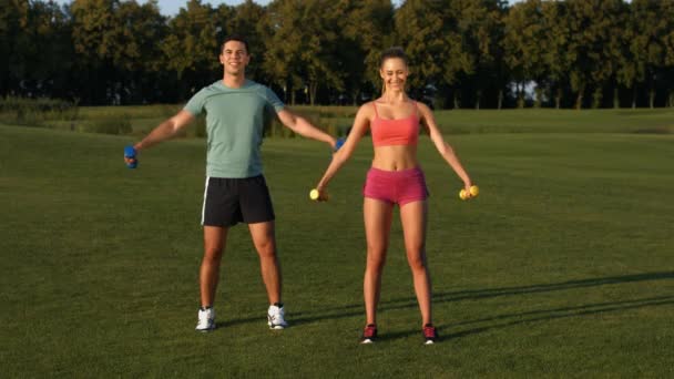 Парень с девушкой занимается фитнесом в красивом парке . — стоковое видео