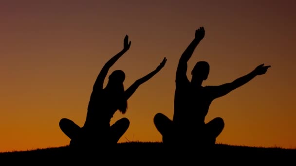 Boy and girl waving their hands at sunset. — Stock Video