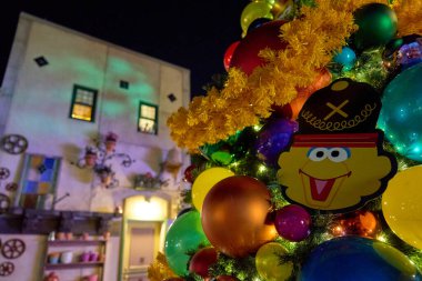 Orlando, Florida, ABD - 11.15.2024: Büyük süsler ve sarı çelenkler yumuşak bokeh 'e karşı parlıyor. Sıcak gece sahnesi sıcak ve neşeli hissettiriyor..