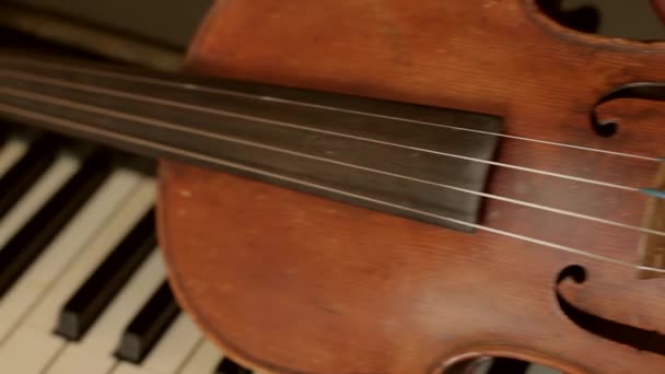 Vieux violon couché sur les touches du piano . — Video