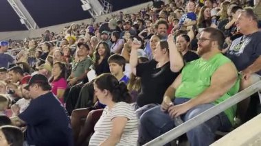 Orlando, Florida, ABD - 03.02.2024: Canlı bir stadyum etkinliği sırasında büyük bir seyirci kitlesi izliyor ve tezahürat yapıyor. Farklı yaşlardaki insanlar eğlenmeyi seviyor ve seyirciler arasında birlikte kutluyorlar..
