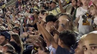 Orlando, Florida, ABD - 03.02.2024: Büyük bir seyirci kitlesi canlı bir stadyum etkinliği sırasında alkış ve tezahürat yapıyor. İnsanlar birlikte heyecan ve coşkuyla kutluyor..