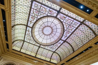 Karmaşık çiçek desenli çarpıcı bir vitray tavanı ve büyük bir New York otelinin içini kaplayan dairesel bir süs. Detaylı işçilik ve pastel tonlar zamansız zarafet ve sofistike bir atmosfer yaratıyor..