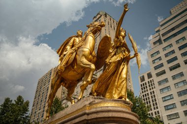 General William Tecumseh Sherman 'ın altın heykeli Grand Army Plaza' da gün ışığında parlıyor. Tarihi ve modern binalarla çevrili bina, New York 'ta çarpıcı bir dönüm noktasıdır..