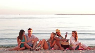 Erkekler ve kızlar eğlenceli şarkı ve gitar çalmak.