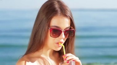 Güzel kız deniz arka planda gülümsüyor.