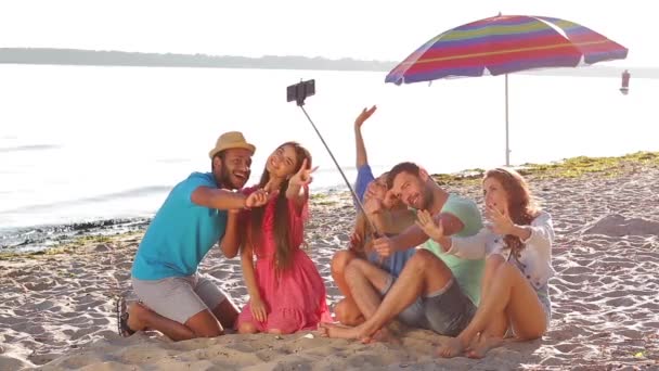 Веселые молодые люди делают селфи на пляже . — стоковое видео