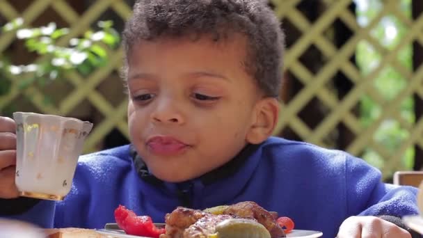 Mulat chłopiec łapczywie jeść. — Wideo stockowe