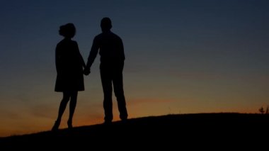 Gün batımına hayran olan aşık çift.