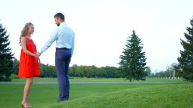 Güzel bir park ortasında kız teklifi yapan adam.