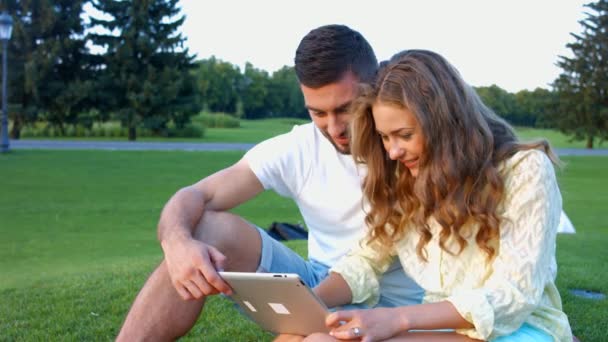 Juegos de azar chico y chica jugando juegos en una tableta . — Vídeos de Stock