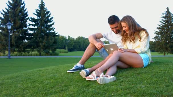 En pareja enamorada relajándose en el parque . — Vídeos de Stock