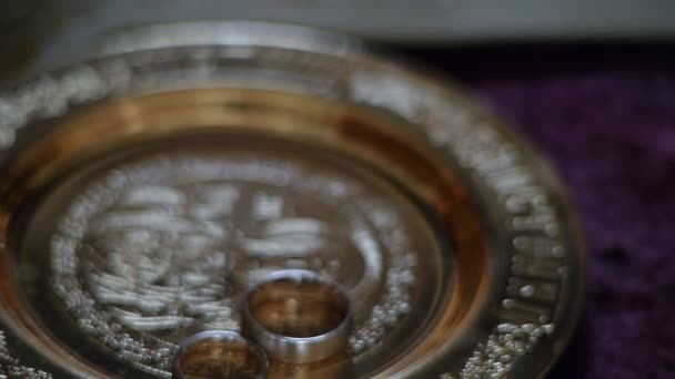 Wedding rings on a saucer in the church. — Stock Video