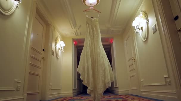 Das Kleid der Braut hängt an einem Kleiderbügel im Flur. — Stockvideo