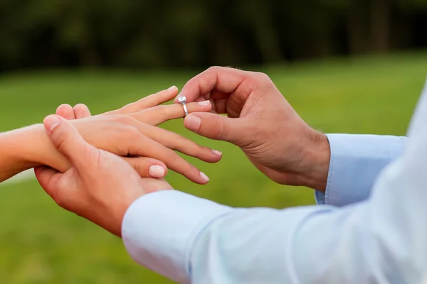 Cara coloca o anel no dedo de sua namorada. — Fotografia de Stock