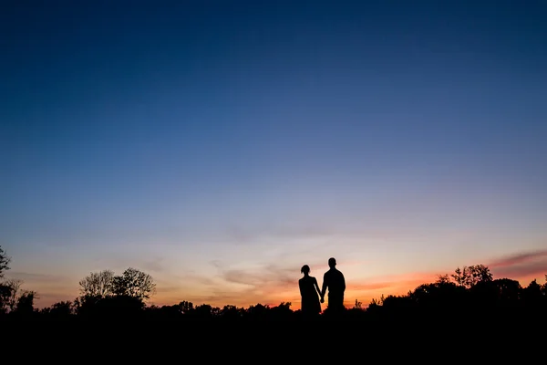 Paar in liefde lopen bij zonsondergang. — Stockfoto