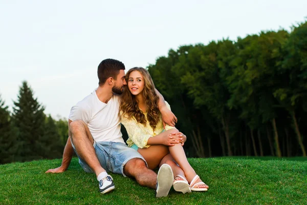 Jongen en meisje knuffelen in het park. Avond-datum. — Stockfoto