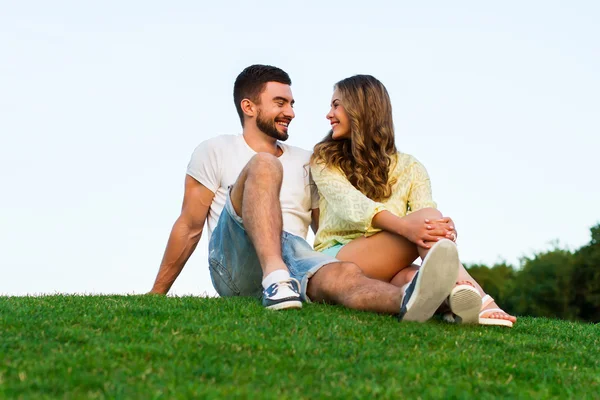 Романтическая поездка. Любовники сидят на траве . — стоковое фото