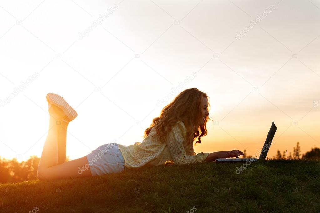 Girl with computer in nature.