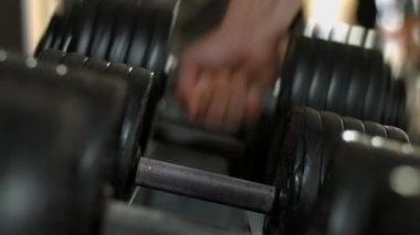 Dumbbell vücut geliştirmeci alır.