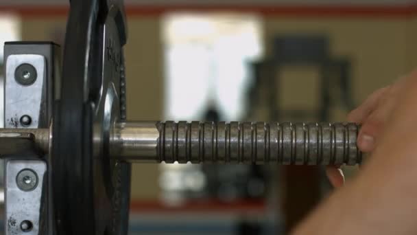 Barbells hanging on metal rack in gym hall. — Stock Video