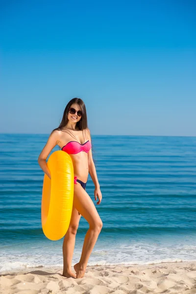 Modelo delgado tomando el sol en la playa . — Foto de Stock