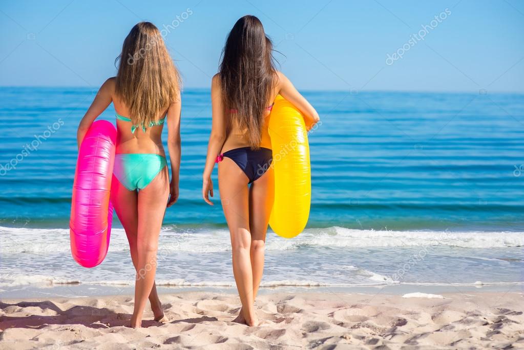 Young sexy girls in swimsuits on the beach. Stock Photo by ©Denisfilm  99456178