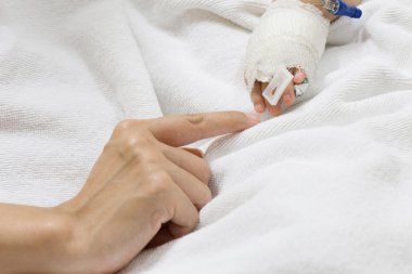 Anne bebek elini tutuyor..