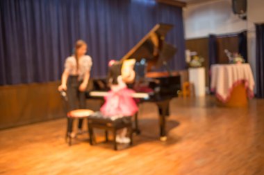 Görüntü, konser salonunda piyano çalan çocuk bulanıklık.