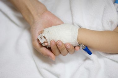 Anne bebek elini tutuyor..