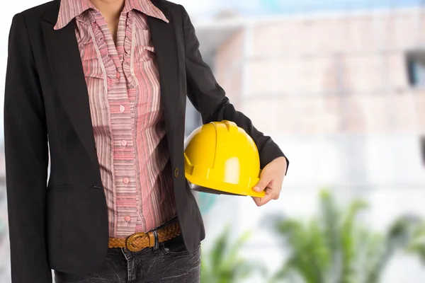 Ingenjör hålla gul hjälm för arbetstagarnas säkerhet på bak — Stockfoto