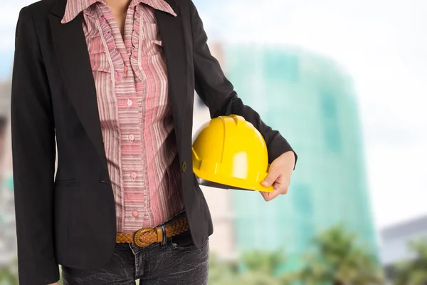 Ingenjör hålla gul hjälm för arbetstagarnas säkerhet på bak — Stockfoto