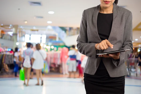 Alışveriş merkezinde tablet kullanan kadın.