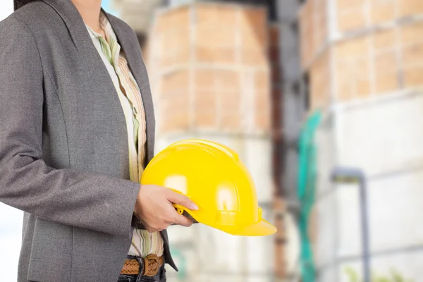 Engineer holding yellow helmet for workers security on backgroun — Stock Photo, Image