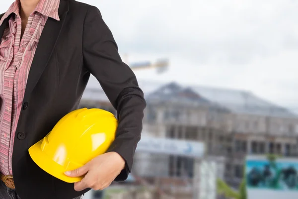 Engineer holding yellow helmet for workers security on backgroun — Stock Photo, Image