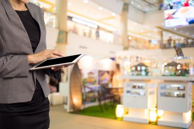 Alışveriş merkezinde tablet kullanan kadın.