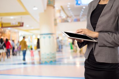 Alışveriş merkezinde tablet kullanan kadın.