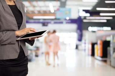 Alışveriş merkezinde tablet kullanan kadın.