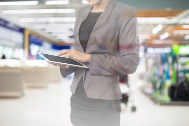 Alışveriş merkezinde tablet kullanan kadın.