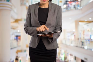 Alışveriş merkezinde tablet kullanan kadın.