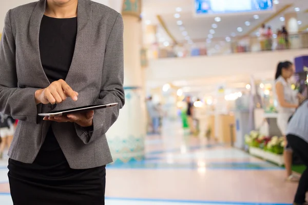 Alışveriş merkezinde tablet kullanan kadın.