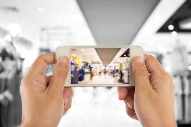 Alışveriş alışveriş merkezinde bir cep telefonu fotoğraf çekmeye kadın.