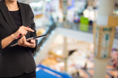 Alışveriş merkezinde dijital tablet kullanarak iş kadını.