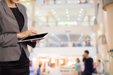 Alışveriş merkezinde tablet kullanan kadın.