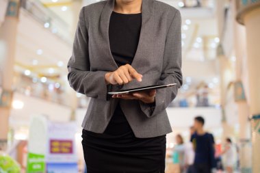 Alışveriş merkezinde tablet kullanan kadın.