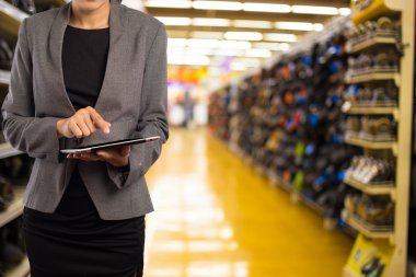 Alışveriş merkezinde tablet kullanan kadın.